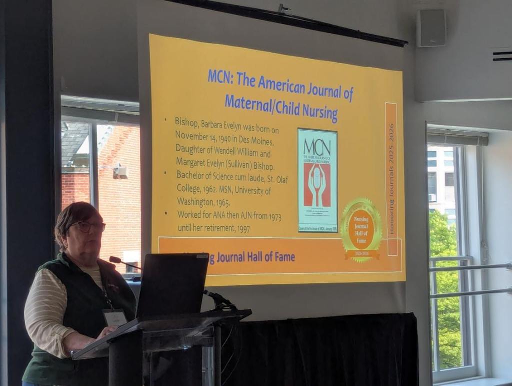 A speaker at the Nursing Journal Hall of Fame Ceremony, presenting information about Barbara Evelyn Bishop and the American Journal of Maternal/Child Nursing.