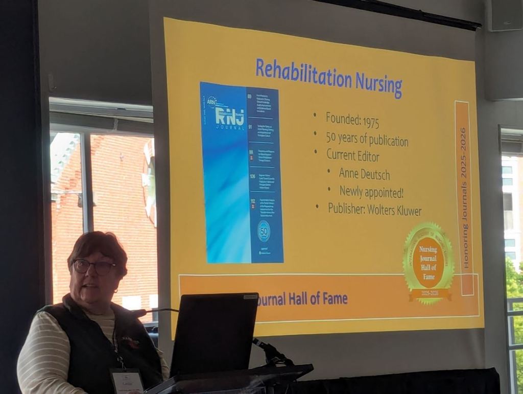 A speaker presents information about the Rehabilitation Nursing journal during the Nursing Journal Hall of Fame Ceremony, highlighting its history and current editor.