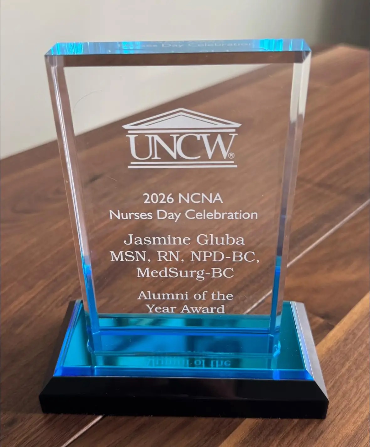 Close-up of Jasmine Gluba’s 2026 Alumni of the Year Award from the University of North Carolina Wilmington.